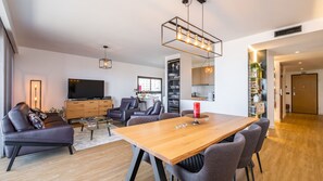 En moderne stue med TV, sofa og spiseplads.