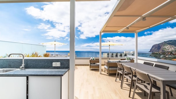 A modern outdoor kitchen area with a view of the ocean and a cliff. - SkyView Penthouse by LovelyStay (Funchal)
