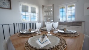A dining table set with plates, glasses, and a napkin. - Ozeanica Heights by LovelyStay (Gaula)