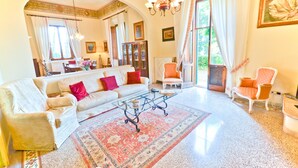 Un salon spacieux comprenant un canapé, des fauteuils, une table basse et un tapis à motifs.