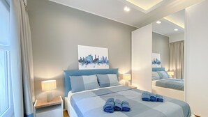 Ein modernes Schlafzimmer mit einem großen Bett, einem Stadtbild und einem Spiegel.