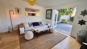 A modern living room with a sofa, coffee table, and a large window.