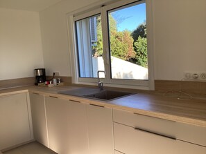 A modern kitchen with a window, a sink, and a countertop.