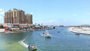 Uma marina com barcos, um hotel grande e uma praia.