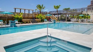 A swimming pool with lounge chairs and a wooden deck. - VillaSolare-Sandestin: 9th-Floor Gulf-Front+Views (Miramar Beach)