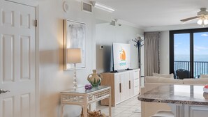 A modern kitchen with a central island, a dining area with a view, and a living space with a ceiling fan. - VillaSolare-Sandestin: 9th-Floor Gulf-Front+Views (Miramar Beach)