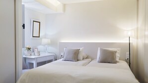 A hotel room with a large bed, bedside tables, a desk, and a lamp. - Apartamentos do Mar - Pikis Flat (Funchal)