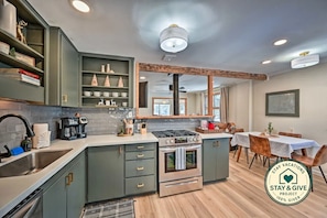 A modern kitchen with a gas stove, a coffee maker, and a sink.