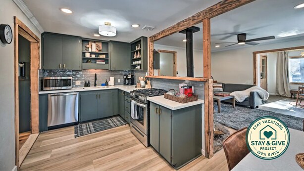 A modern kitchen with built-in appliances, a dining area, and a large mirror. - Flagstaff Forest Retreat • Hot Tub • Fire Pit • Fully Fenced Yard • P... (Flagstaff)