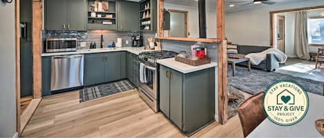 A modern kitchen with built-in appliances, a dining area, and a large mirror.
