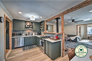A modern kitchen with built-in appliances, a dining area, and a large mirror.
