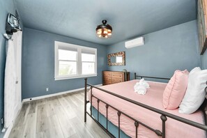 A bedroom with a bed, a window, a ceiling fan, and a dresser. - Rustic 2BR w/ Ping Pong near Beach/Nightlife (Galveston)