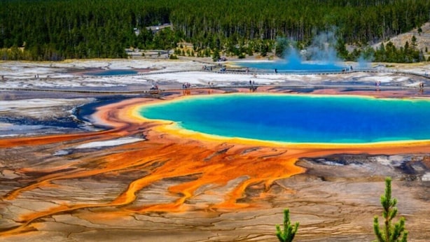 Un área geotérmica con una gran piscina de agua y depósitos minerales.