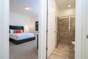 A bedroom with a bed, bedside tables, and a nightstand.