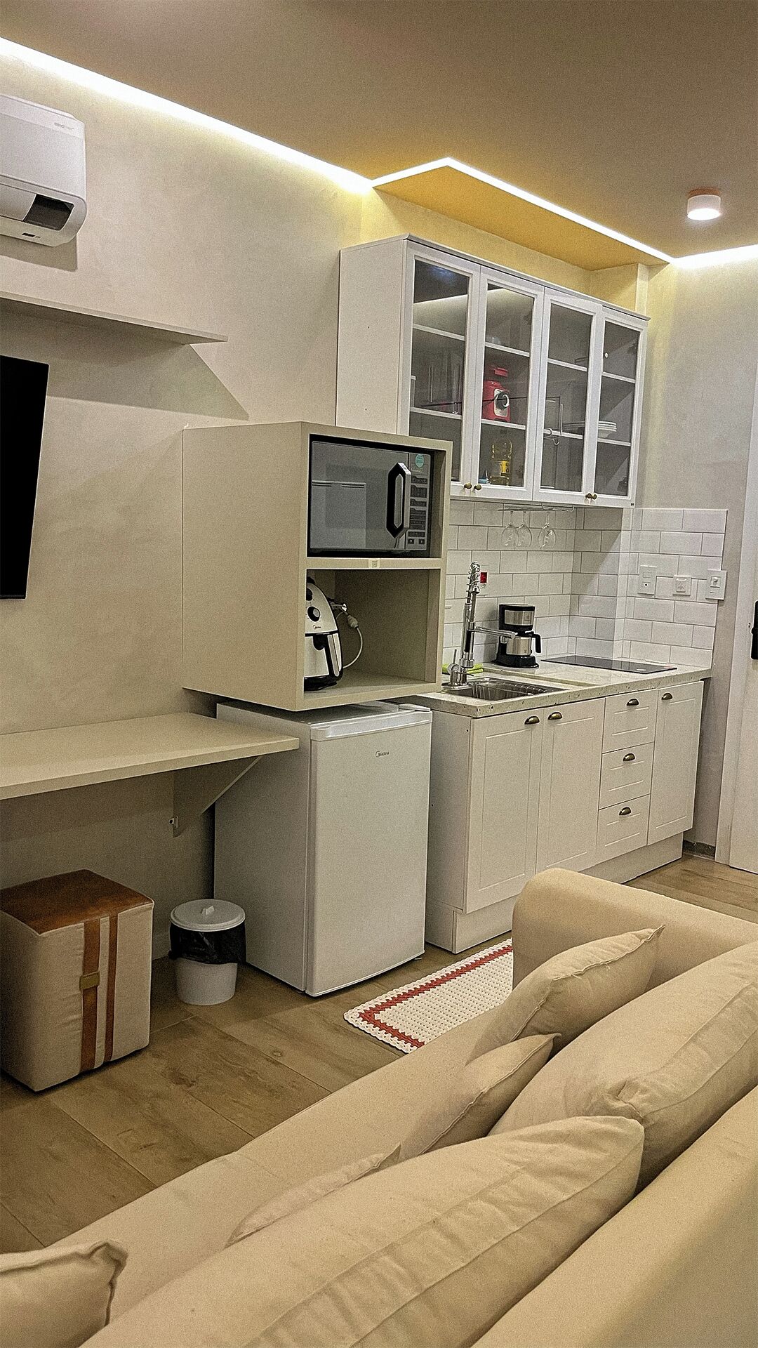 Une cuisine compacte équipée d’un four à micro-ondes, d’une machine à café et de placards.