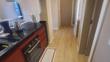 Apartamento Deluxe | Cocina privada | Frigorífico, microondas, horno y placa de cocina