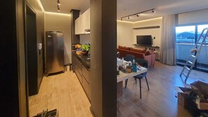 A modern living space with a kitchen, dining area, and a balcony. - Apart-hotel Theotókos Flats (Piumhi)