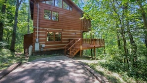 A wooden cabin with a balcony, surrounded by trees. - Pet-Friendly Townsend Mtn Cabin w/ Hot Tub & Daybed Patio (Townsend)