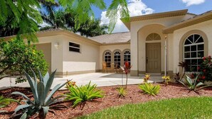 A house with a patio, a door, and a window. - Alecia -Gulf access Home (Cape Coral)