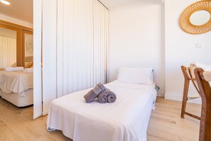 Ein Hotelzimmer mit Bett, Stuhl, Spiegel und Tür.