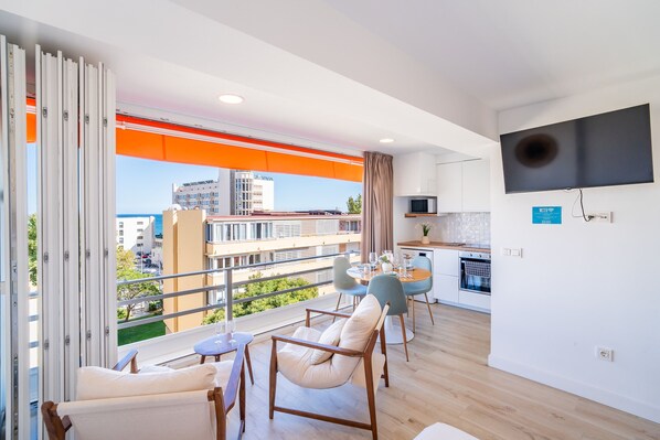 A modern apartment with a balcony, a dining area, and a kitchen.