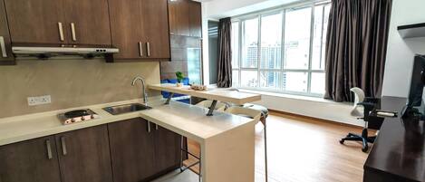 Una cocina moderna con una isla integrada, un ventanal con cortinas y vistas a la ciudad.
