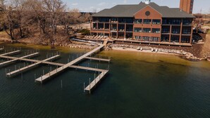 A large building with multiple balconies overlooking a body of water, connected by a dock. - The Shoreline Hotel (Spring Park)