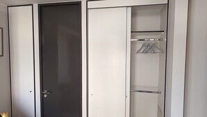Een inloopkast met een spiegel en een deur.