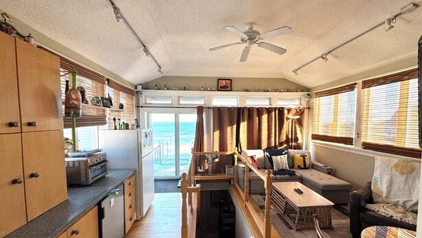 Un espacio habitable compacto con kitchenette, comedor y zona de estar con vista al océano.