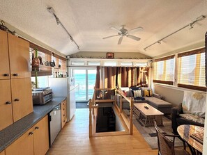 A compact living space with a kitchenette, a dining area, and a seating area with a view of the ocean. - The view of the beach from the penthouse deck  resort with AC in charm Salisbury (Salisbury)