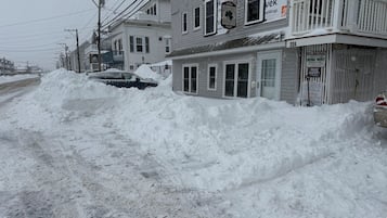 Rua residencial com casas, um monte de neve e uma placa indicando vaga de estacionamento exclusiva para moradores da Irish Mist.