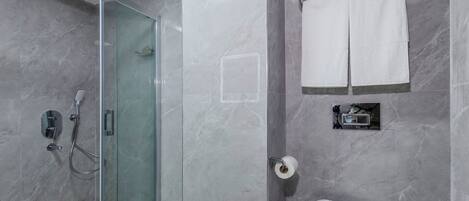 A modern bathroom with a glass shower enclosure, a toilet, and a sink.
