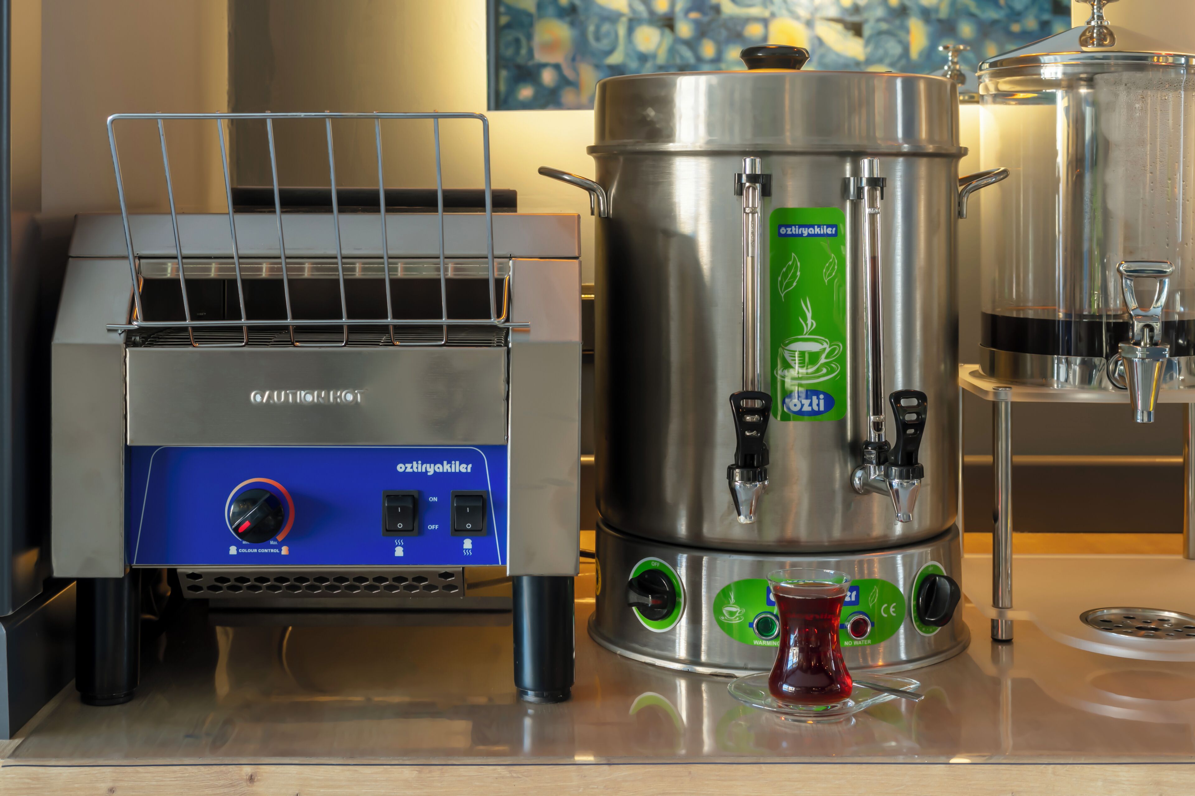 A coffee machine and a large stainless steel pot on a countertop.