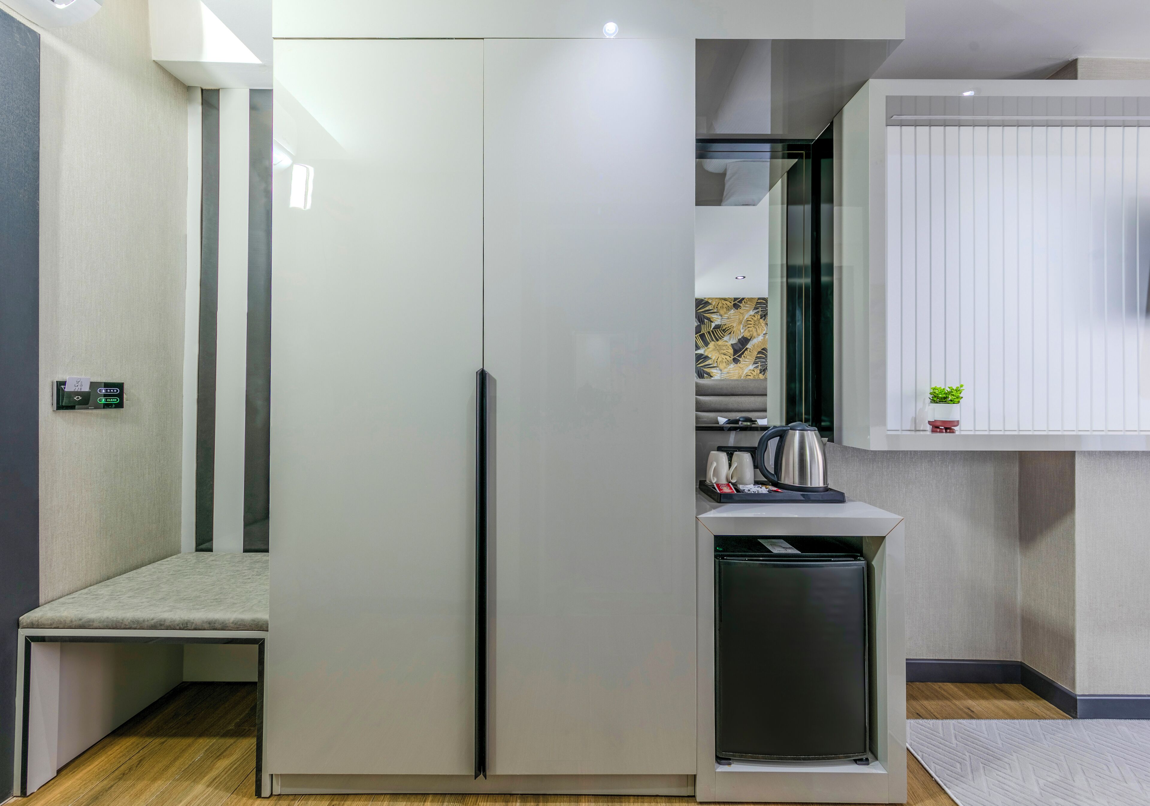 A compact kitchen with a built-in refrigerator, a small countertop, and a seating area.