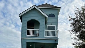 Un immeuble de deux étages doté d’un balcon à l’étage supérieur et d’un escalier menant à l’entrée.