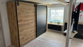 Eine moderne Küche mit Holzschränken, einer schwarzen Arbeitsplatte und einem Fenster mit Blick ins Grüne.