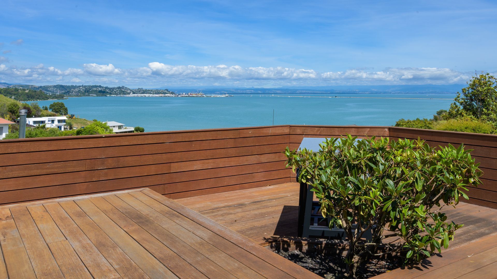 A wooden deck with a view of a coastal landscape.
