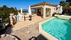 A poolside area with a pool, outdoor seating, and a view of the sea. - Casa Vinti - Vue mer et montagne, piscine (Grosseto-Prugna)