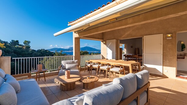 A spacious outdoor patio with a wooden table and chairs, a sofa, and a dining area. - Casa Vinti - Vue mer et montagne, piscine (Grosseto-Prugna)