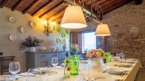 A dining area with a long table set for a meal, featuring striped tablecloths, wine glasses, and plates.