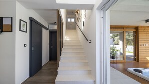 A modern staircase with a wooden floor leading to a second-floor landing.