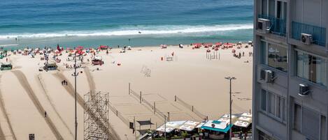 A beach with a road leading to a building.