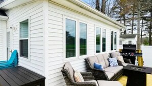 A white mobile home with a deck, outdoor seating, and a grill. - Sleeps 8-Cozy 3-Bedroom Cottage, 2 Blocks from the Strip, 10 Minutes from Spire (Geneva)