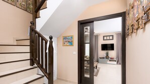 A staircase leading to a living area with a television and a plant. - Home2Book Luxury Villa Pool & Terrace, Corralejo (Corralejo)