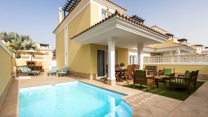 A swimming pool with lounge chairs and a covered patio area. - Home2Book Luxury Villa Pool & Terrace, Corralejo (Corralejo)