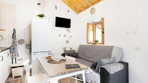 A compact living space with a kitchenette, a dining area, and a seating area with a sofa and a table. - Home2Book Valley Views  & Private Terrace Hermigua (Hermigua)