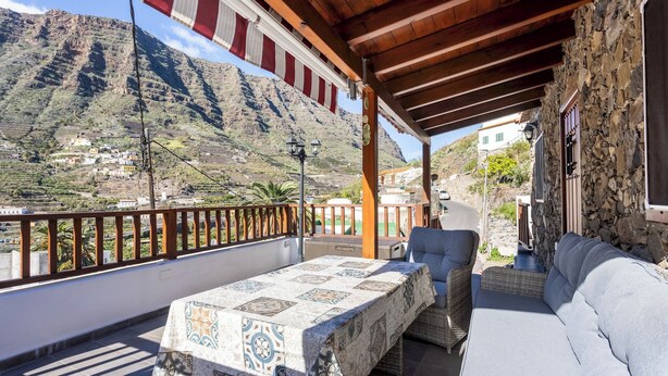A balcony with a table and seating, overlooking a mountainous landscape. - Home2Book Valley Views  & Private Terrace Hermigua (Hermigua)