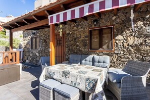An outdoor seating area with wicker furniture and a table covered with a patterned tablecloth. - Home2Book Valley Views & Private Terrace Hermigua (Hermigua)