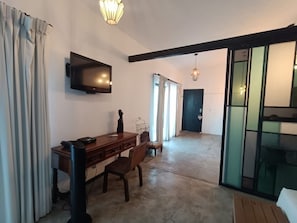 Relax in a stylish room with a dining table, flat-screen TV, and large window.