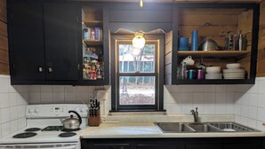A kitchen with a stove, sink, and cabinets. - Trego River House  (Trego)